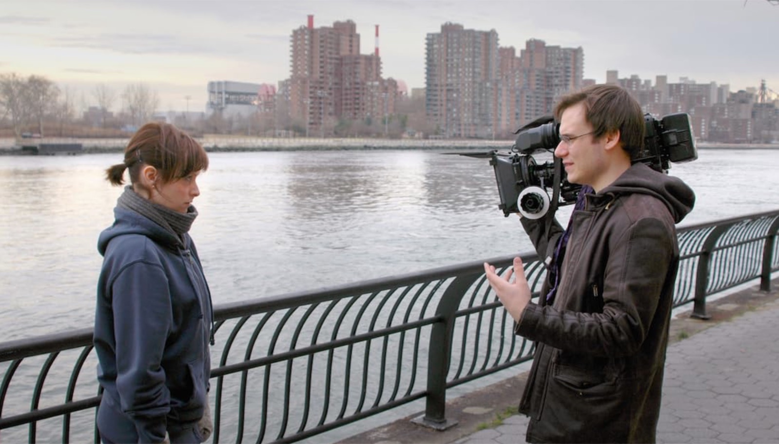 Carlos Ferrer with the camera on his shoulder directing Lindsay Goranson on the East River